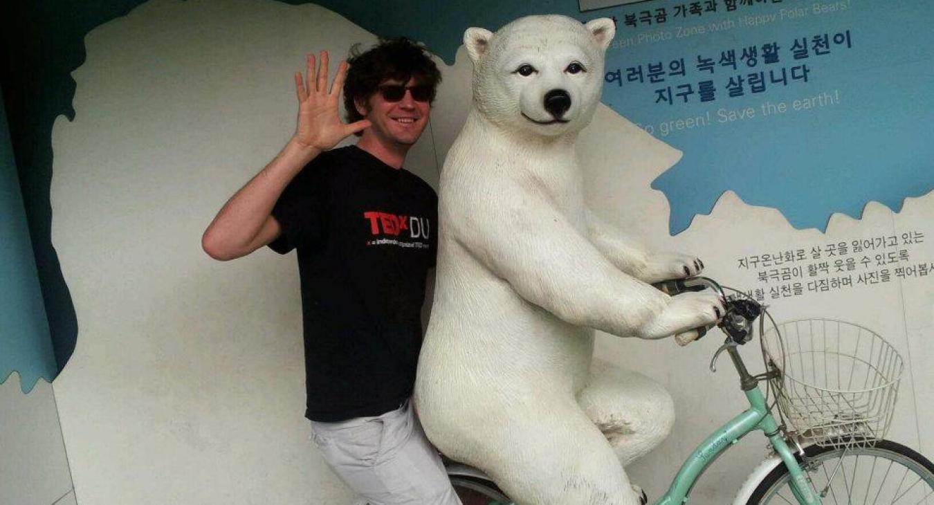 Riding a bike with a bear statue